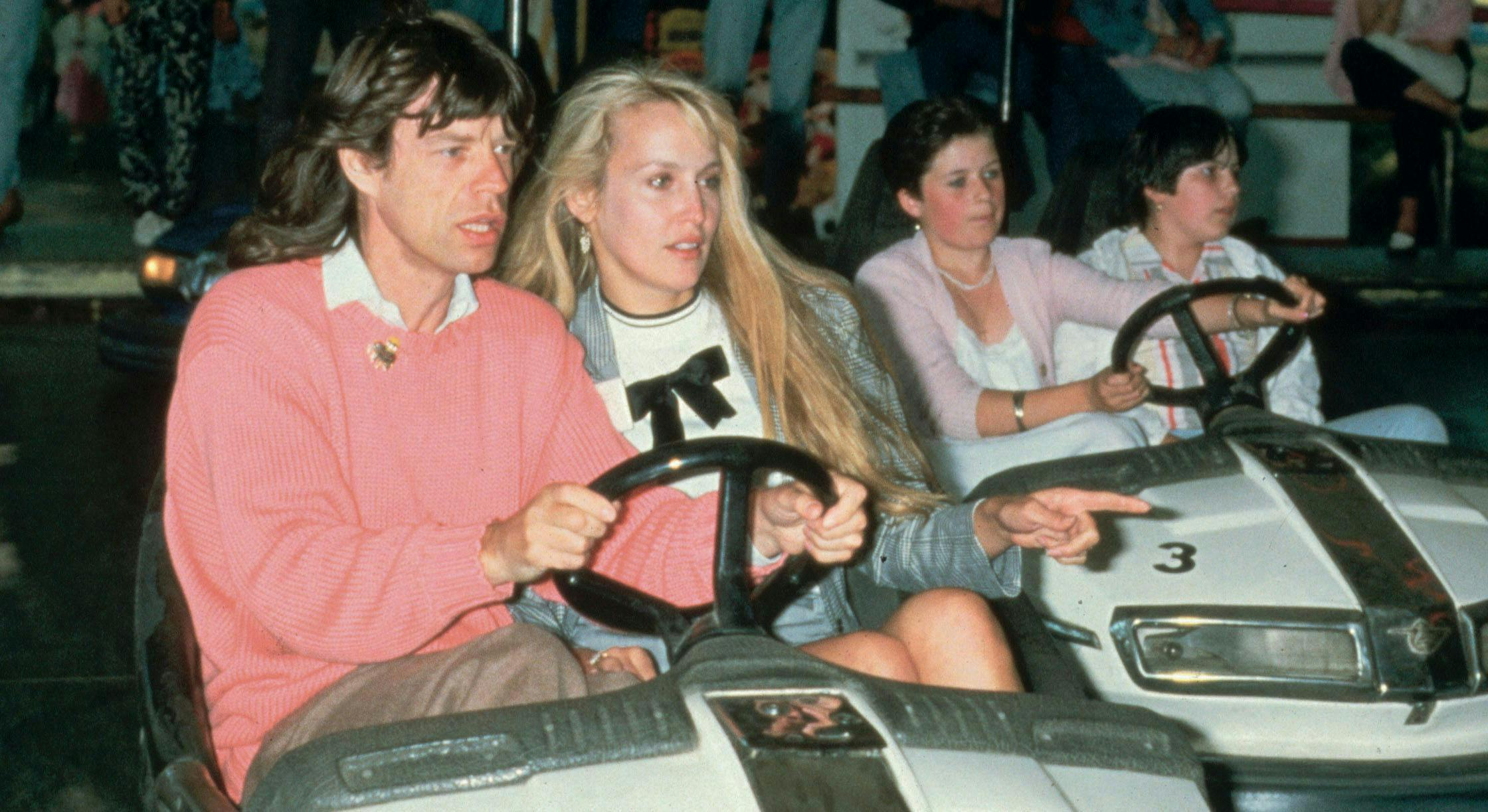 men bumper cars english group of people women recreation girl music mick jagger jerry hall festival american rock music couples caucasian ethnicity prominent persons rolling stones child driving boy person human kart vehicle transportation
