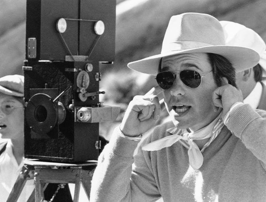 1970s candids 1970s movies 1976 movies bogdanovich,peter candid director ev-in fedora films by peter bogdanovich fingers in ears hat mej movies neckerchief o'neal,tatum on-set clothing apparel person human sunglasses accessories accessory sun hat face