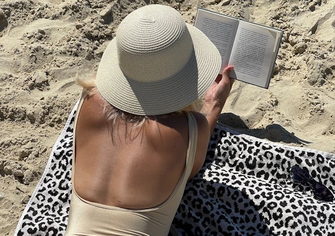 clothing hat person reading adult female woman book sunbathing sun hat